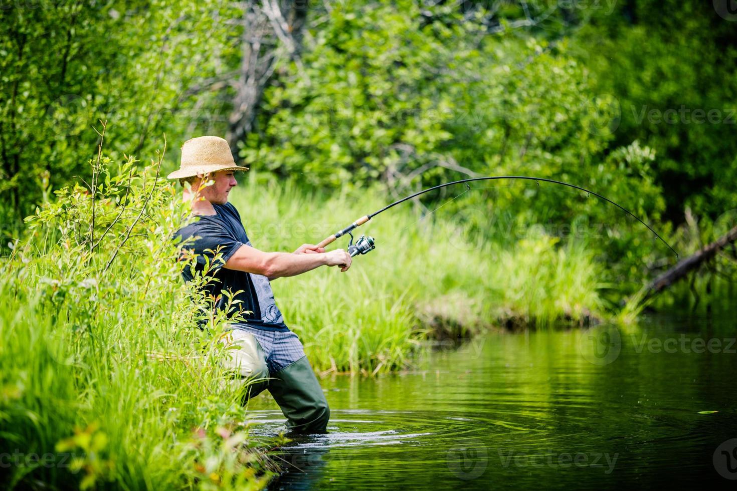 Young Fisherman Catching a big Fish photo