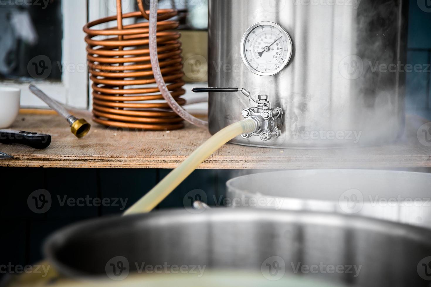 kit de elaboración casera y vertido de mosto de cerveza artesanal en el hervidor de agua. foto