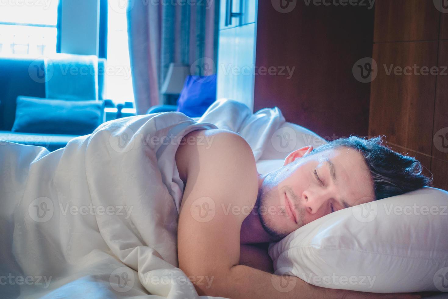 hombre durmiendo solo en el hotel por la mañana foto