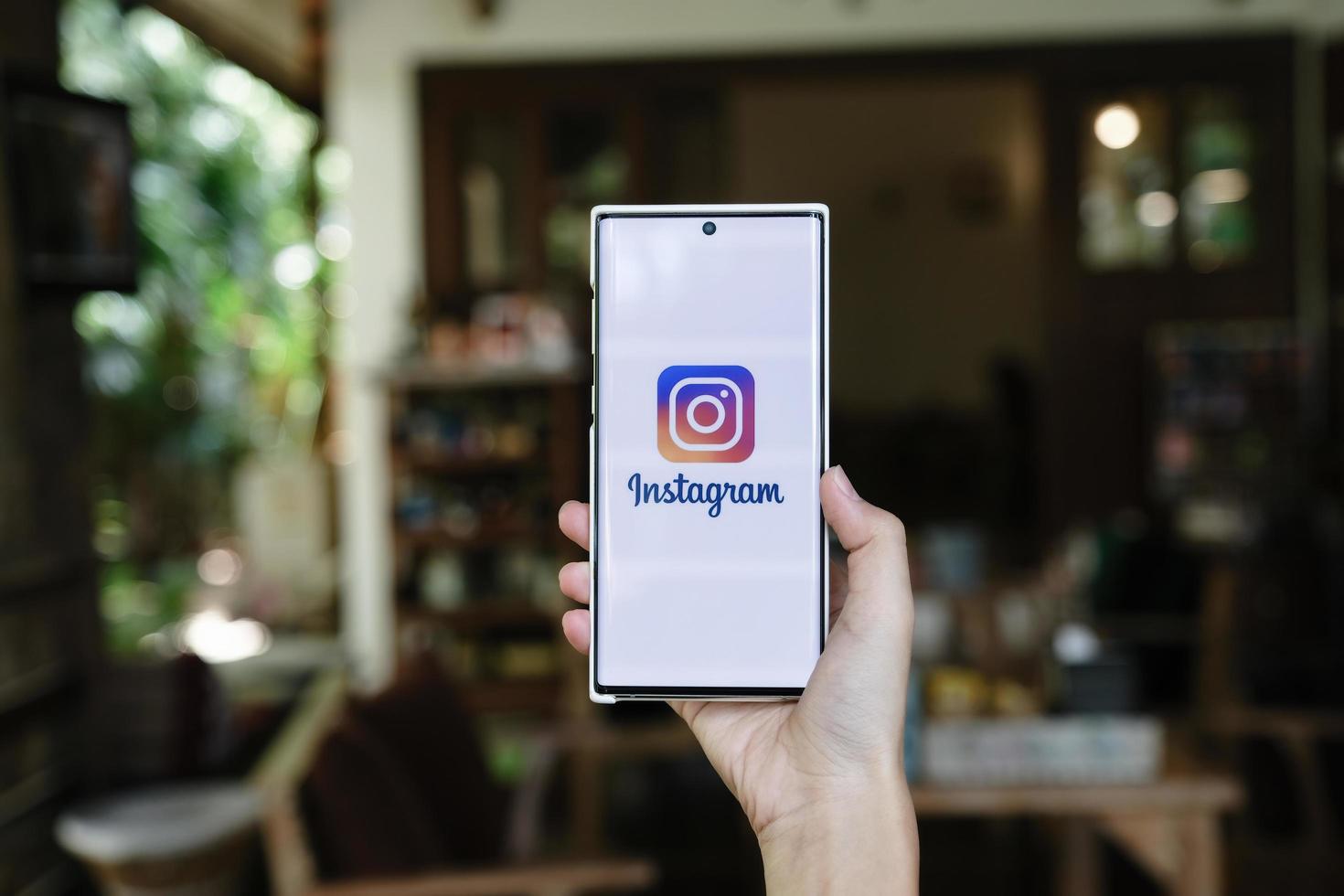 chiangmai, tailandia - 09 de julio de 2021- una mujer sosteniendo un teléfono inteligente con la aplicación de instagram en la pantalla. Instagram es una aplicación para compartir fotos para teléfonos inteligentes.