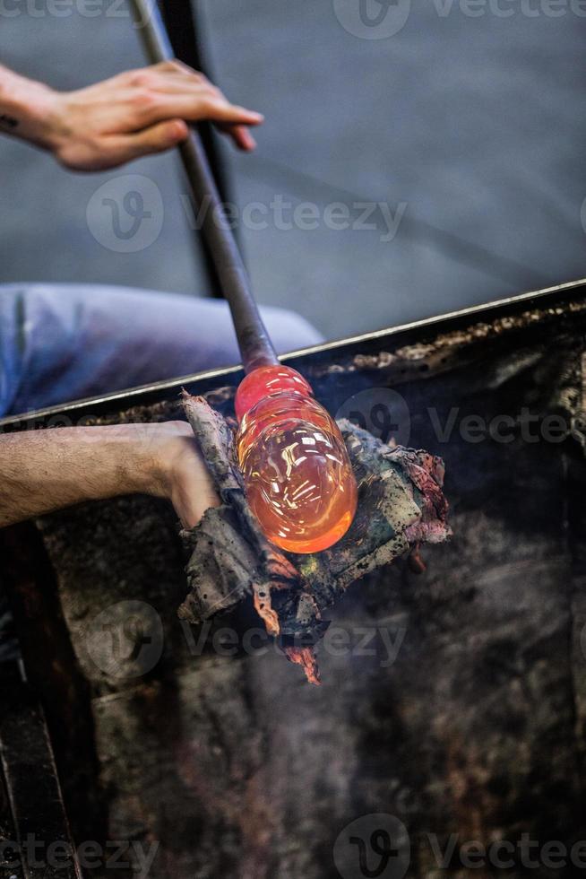 Man Hands Closeup Working on a Blown Glass Piece photo