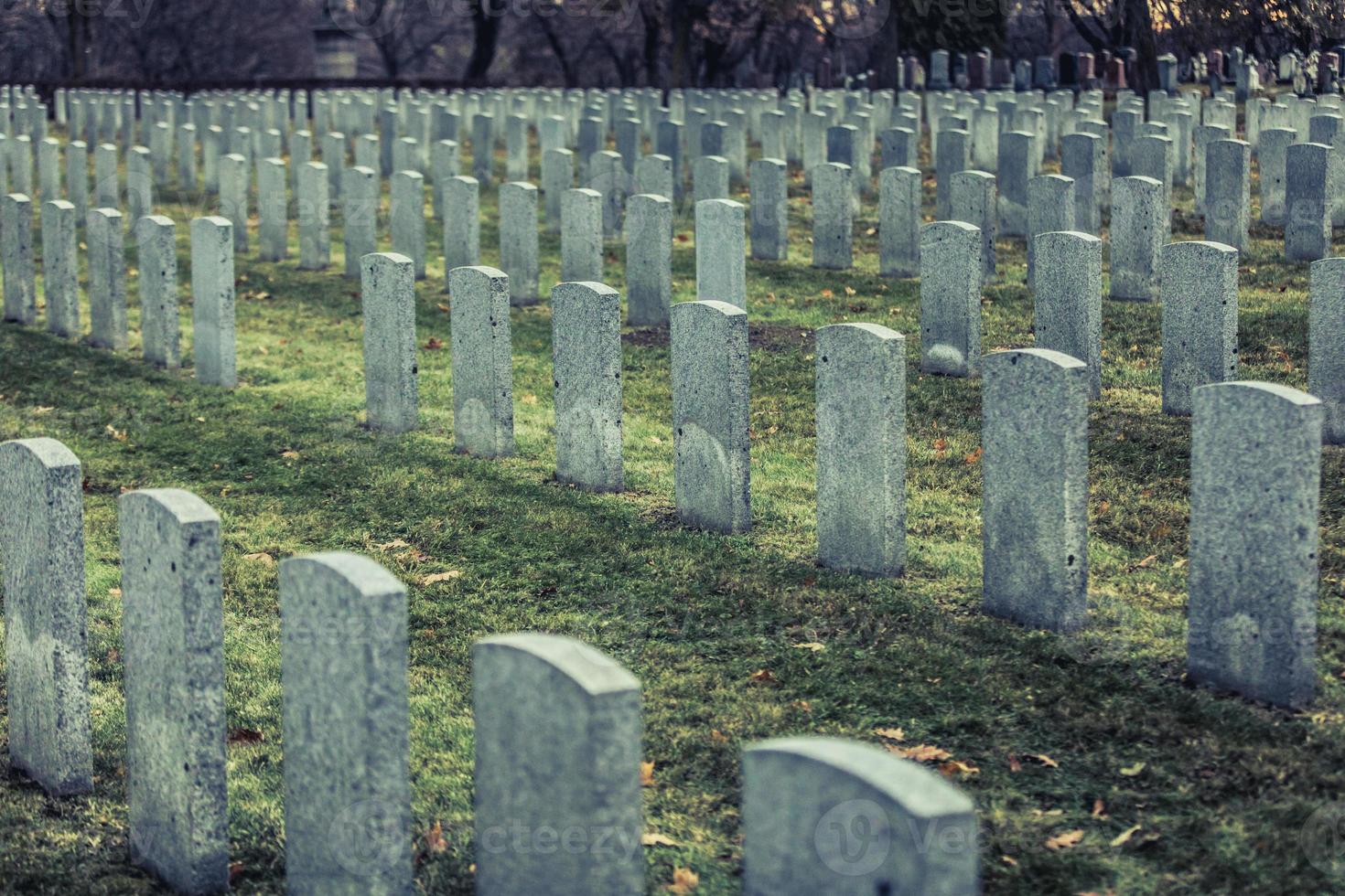 Back of Army Headstone and Graveyard Cemetery during a Sad Day of Autumn. photo