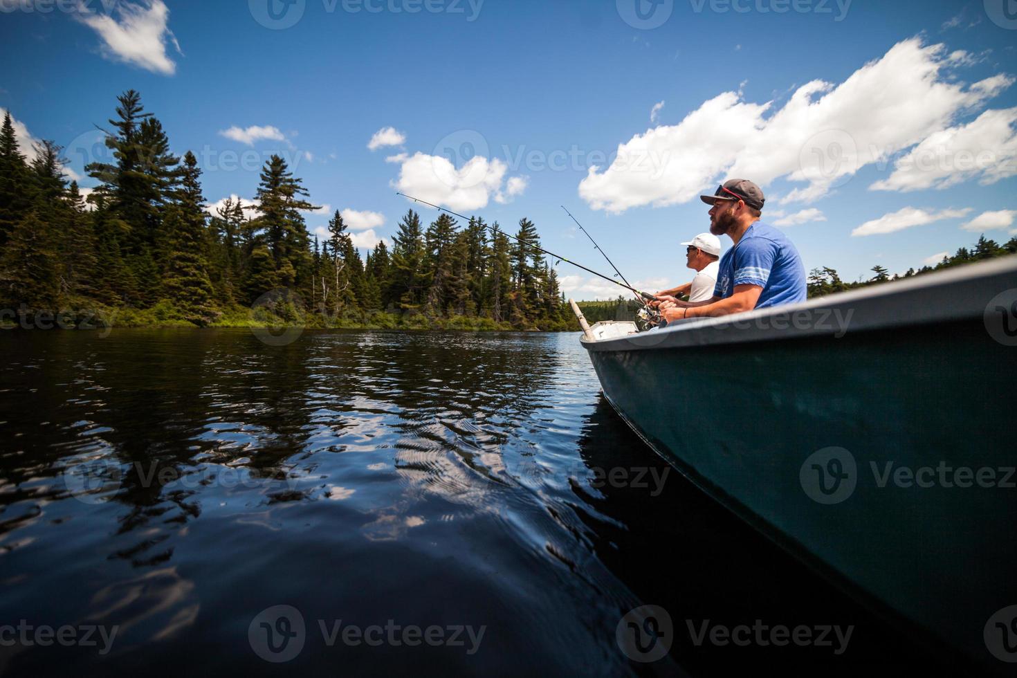 Sun and Father Fishing in a Calm Lake in Wild Nature. photo