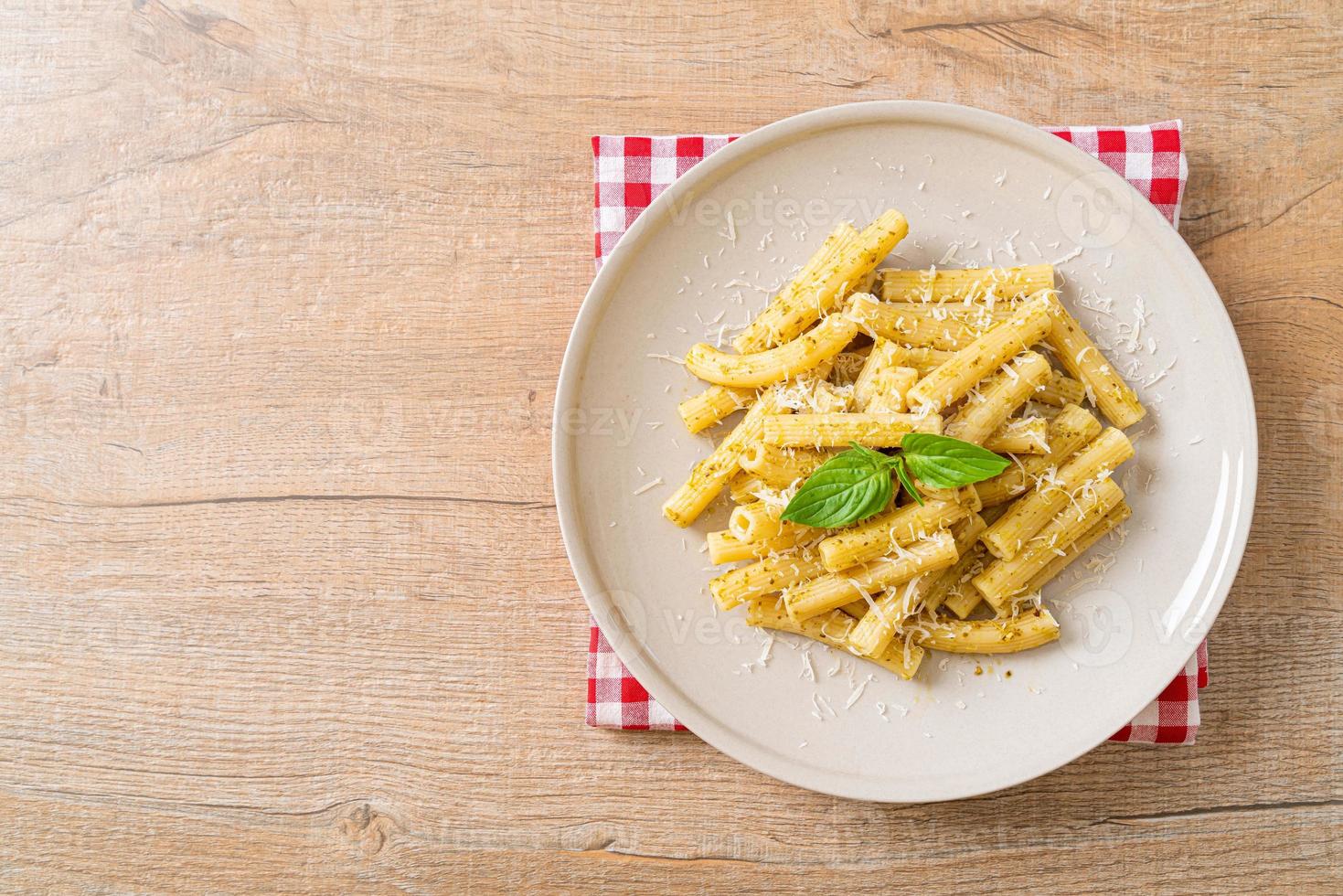 pesto rigatoni pasta with parmesan cheese photo