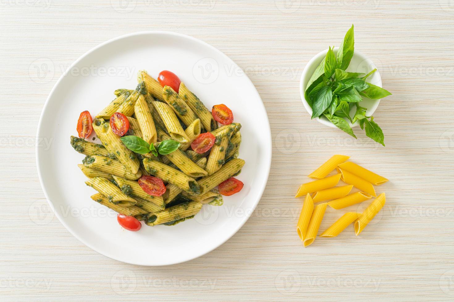 pasta penne con salsa pesto y tomates foto