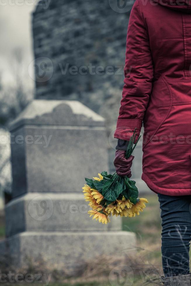 primer plano de un triste delante de una lápida. foto