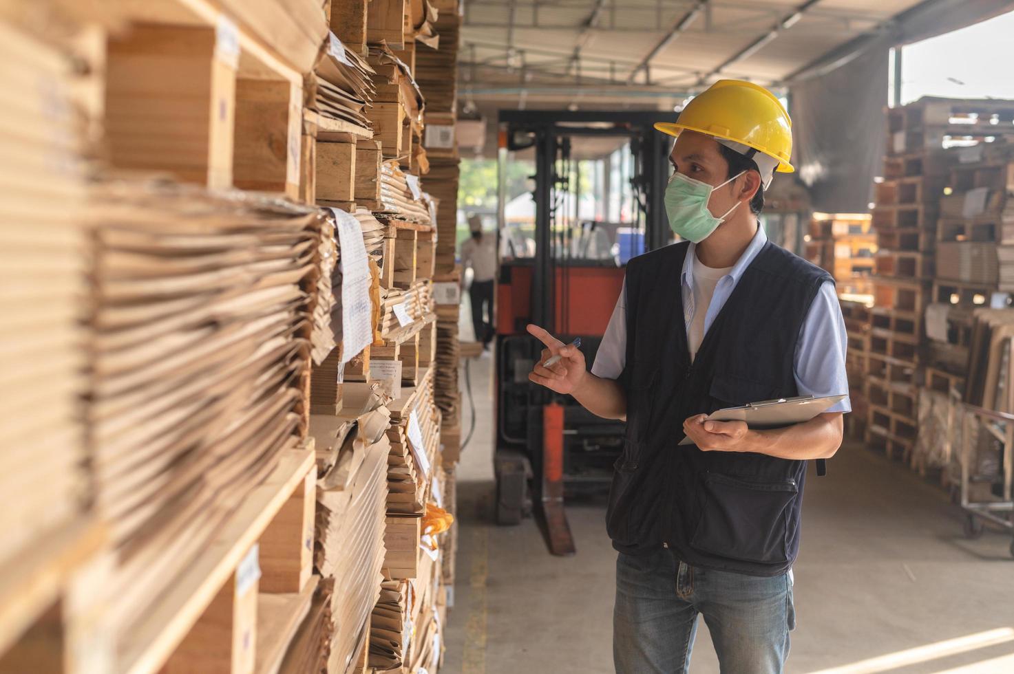 Trabajador comprobando el inventario de materias primas en la fábrica. foto