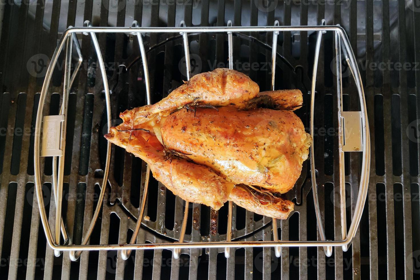 Whole chicken on gas barbeque photo