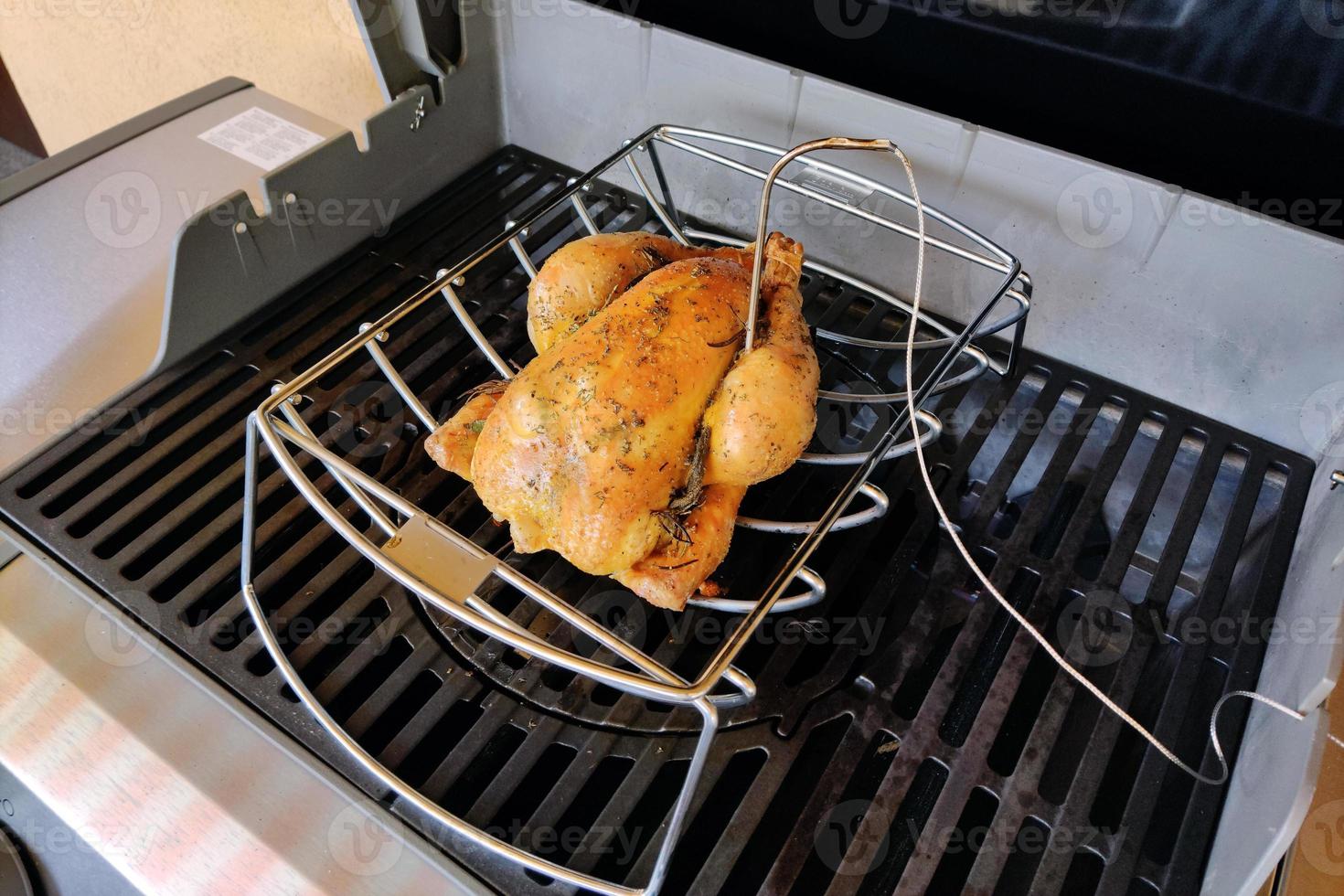 Whole chicken on gas barbeque photo