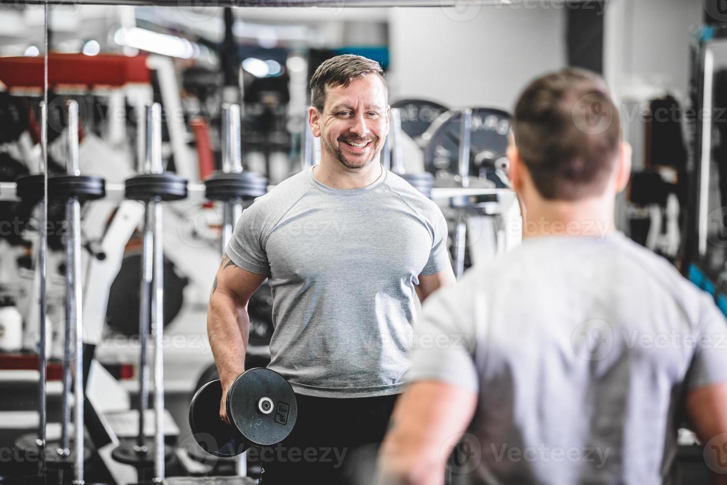 Smiling bodybuilder with dumbbells photo