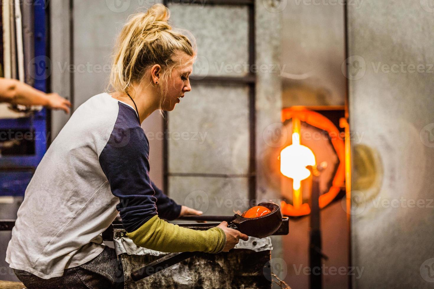 mujer profesional de vidrio soplado trabajando en un jarrón. foto