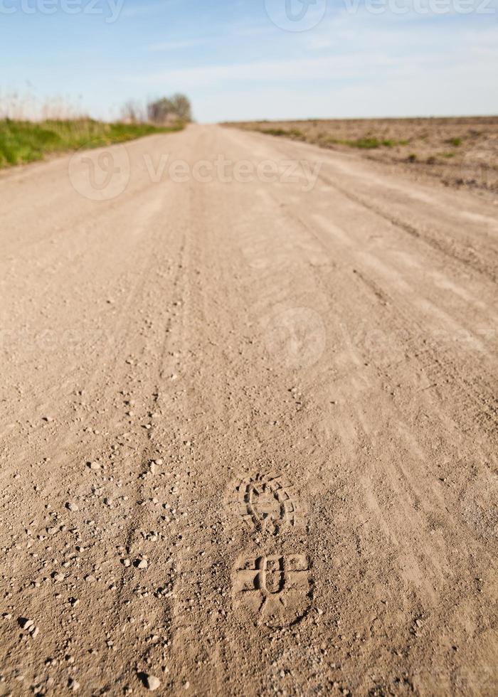 Foot Step in a dusty country road photo