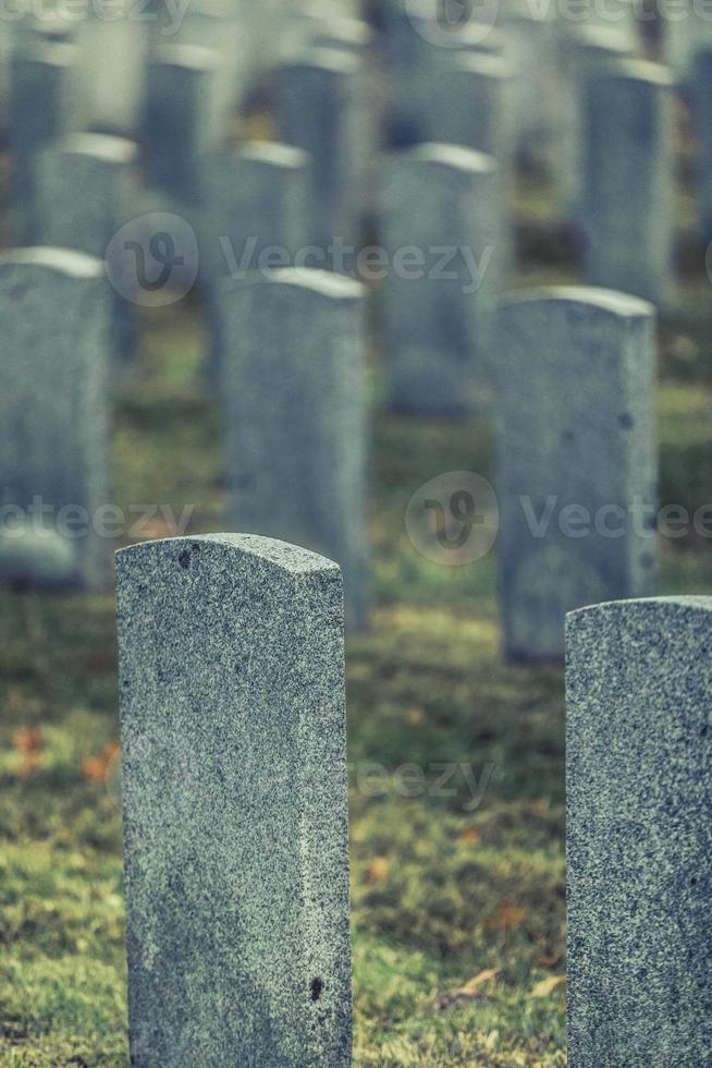 Back of Army Headstone and Graveyard Cemetery during a Sad Day of Autumn. photo