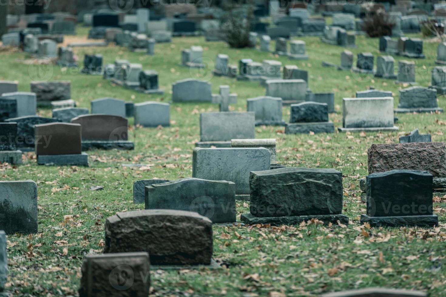 Detrás de las lápidas en un antiguo cementerio en otoño foto