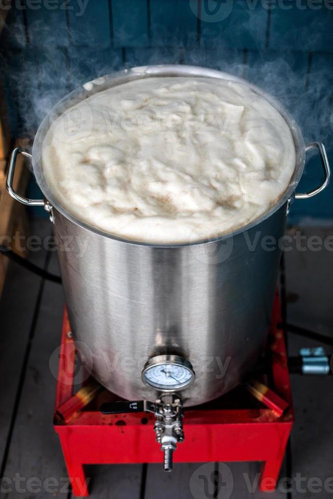 pausa caliente de elaboración casera y mucha espuma de proteína en el hervidor de agua que se calienta. foto