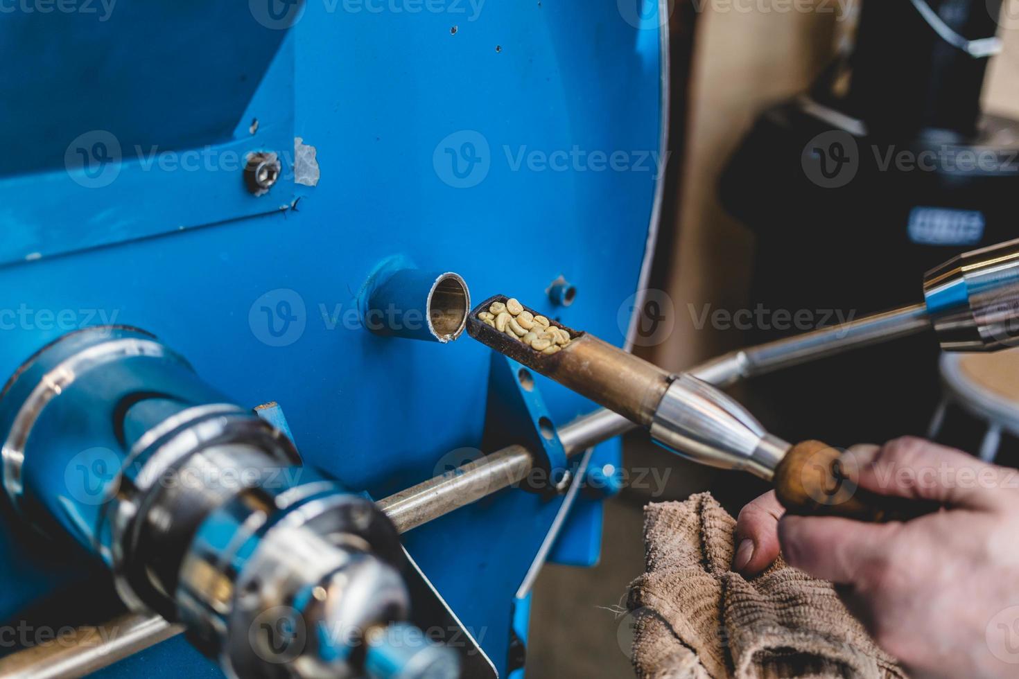 Crop worker checking beans in coffee roaster photo