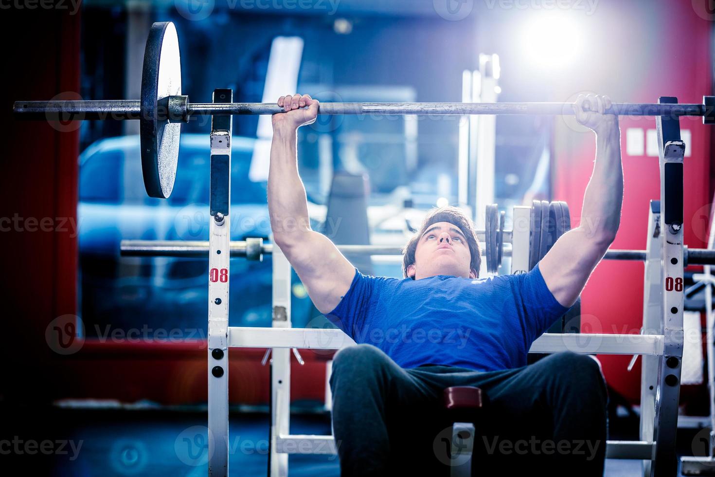 Man doing bench press in gym photo