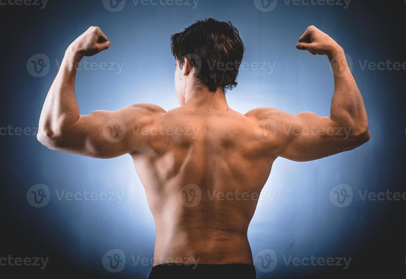 Muscular bodybuilder showing back and shoulders photo