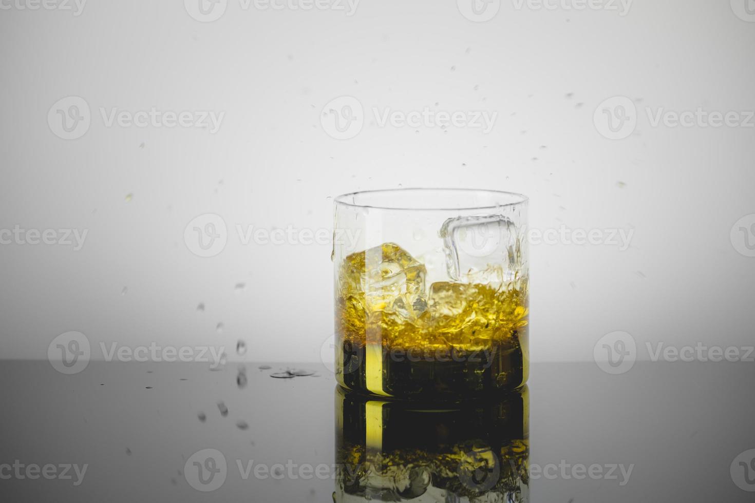 Splashing Glass of Single Malt Whisky over Gray Background photo