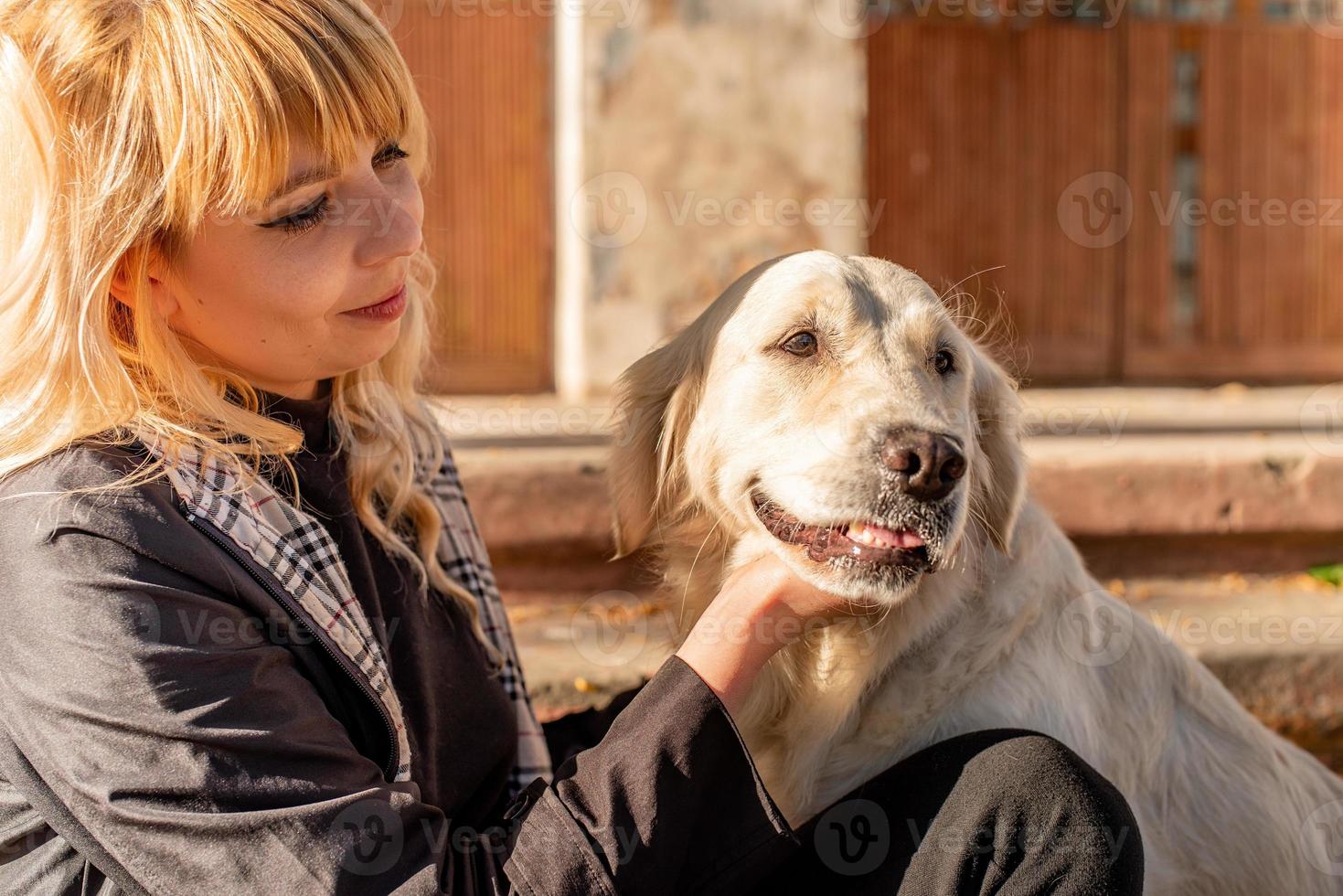 happy caucasian woman enjoying time with her labrador retriever dog in the park photo