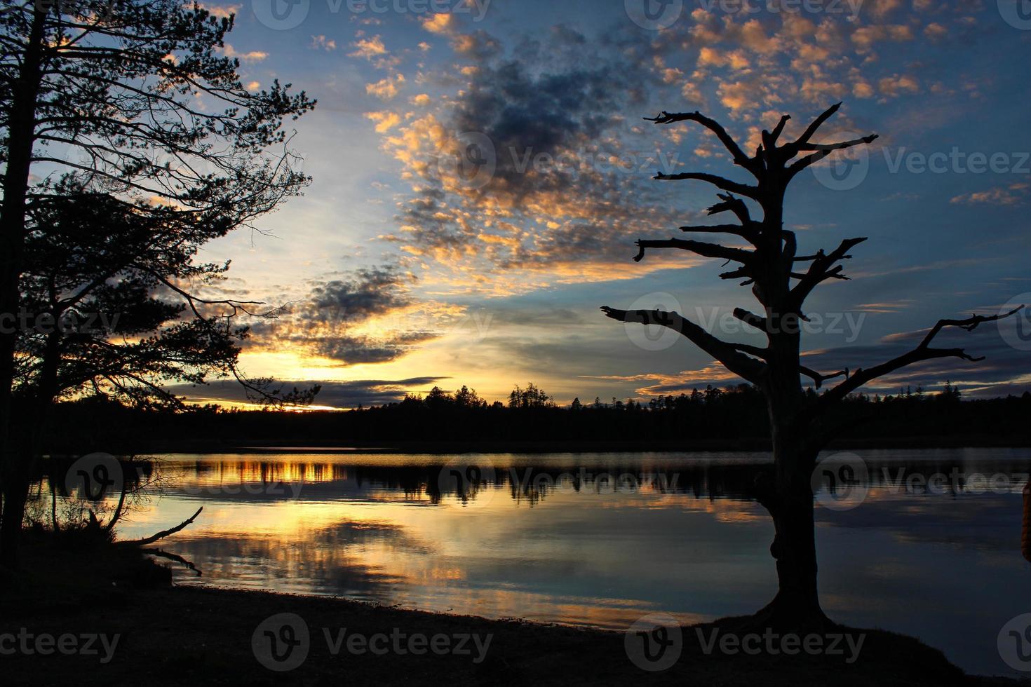 Romantic sunset with unique reflections on a peaceful lake photo