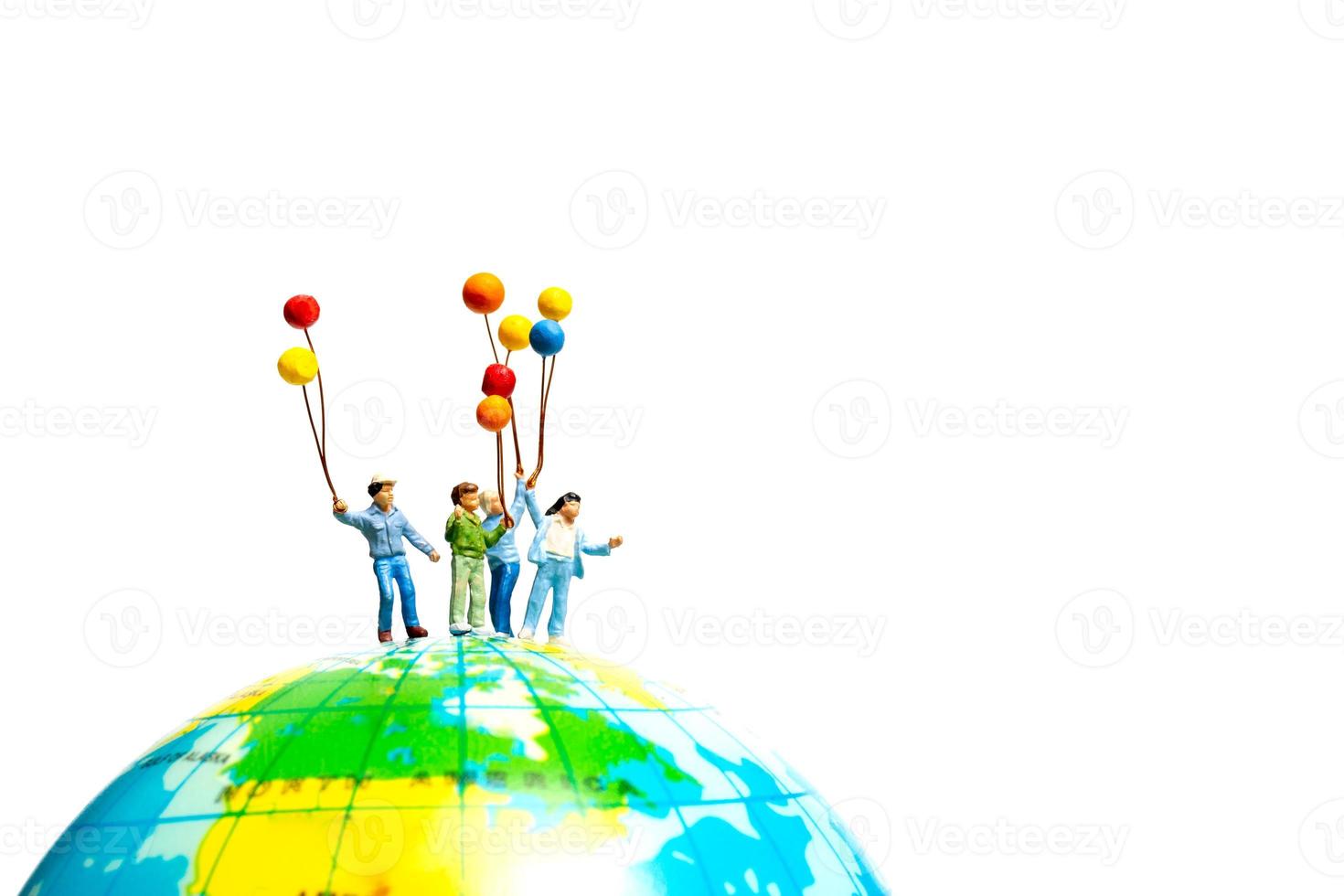 Miniature people , Childrens holding balloons standing on the globe photo