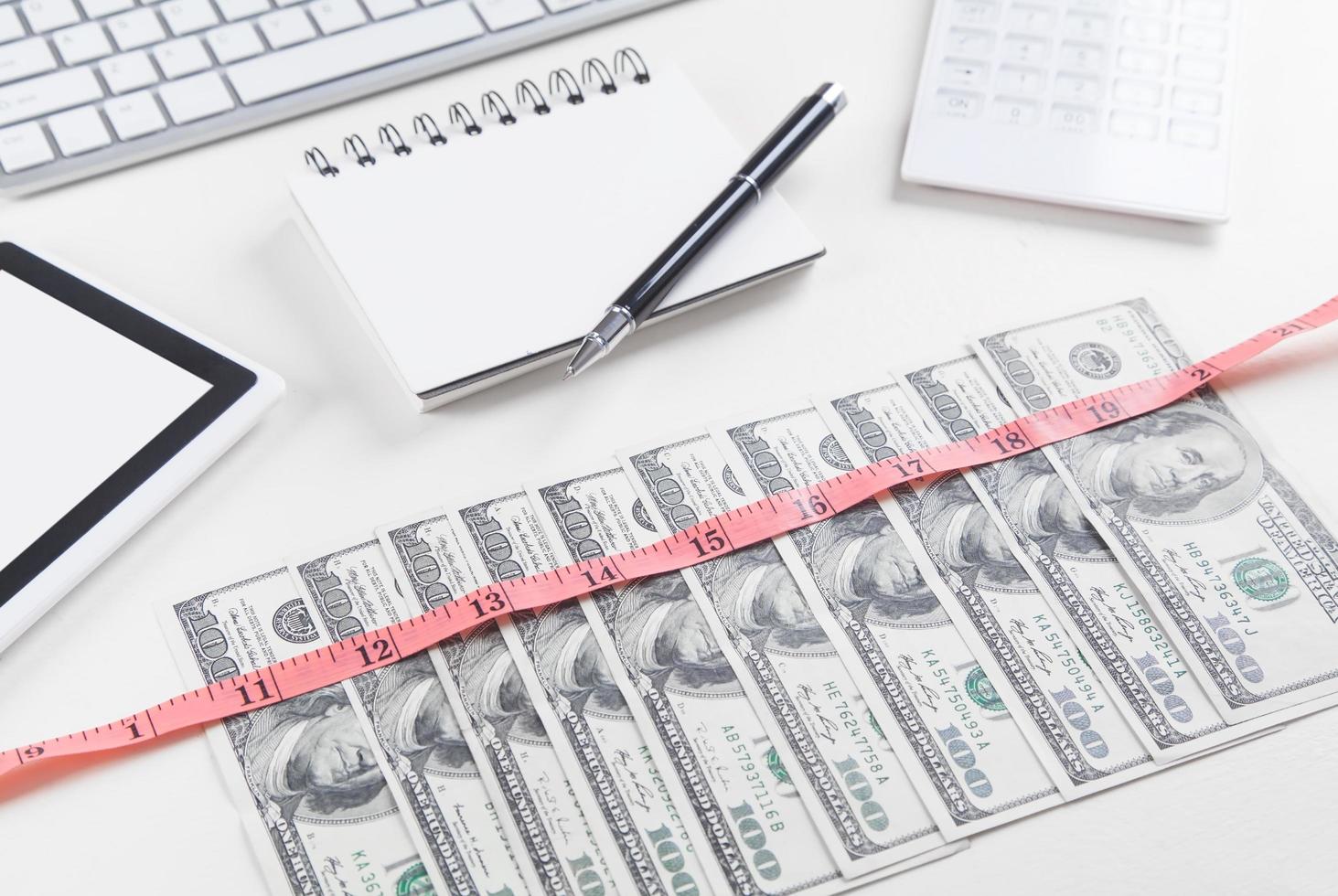 Dollars with measuring tape on the business desk. photo