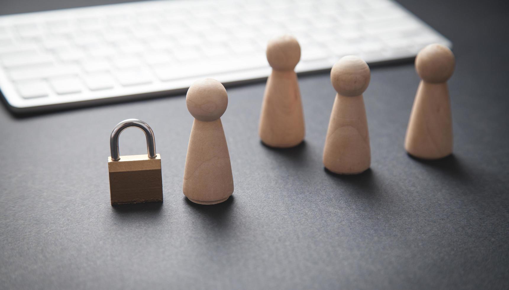 Human wooden figures with a padlock and computer keyboard. Personal data protection photo