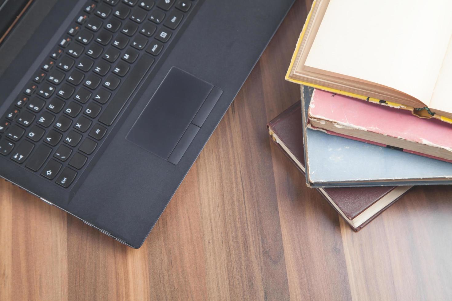 Books and laptop on the wooden table. photo