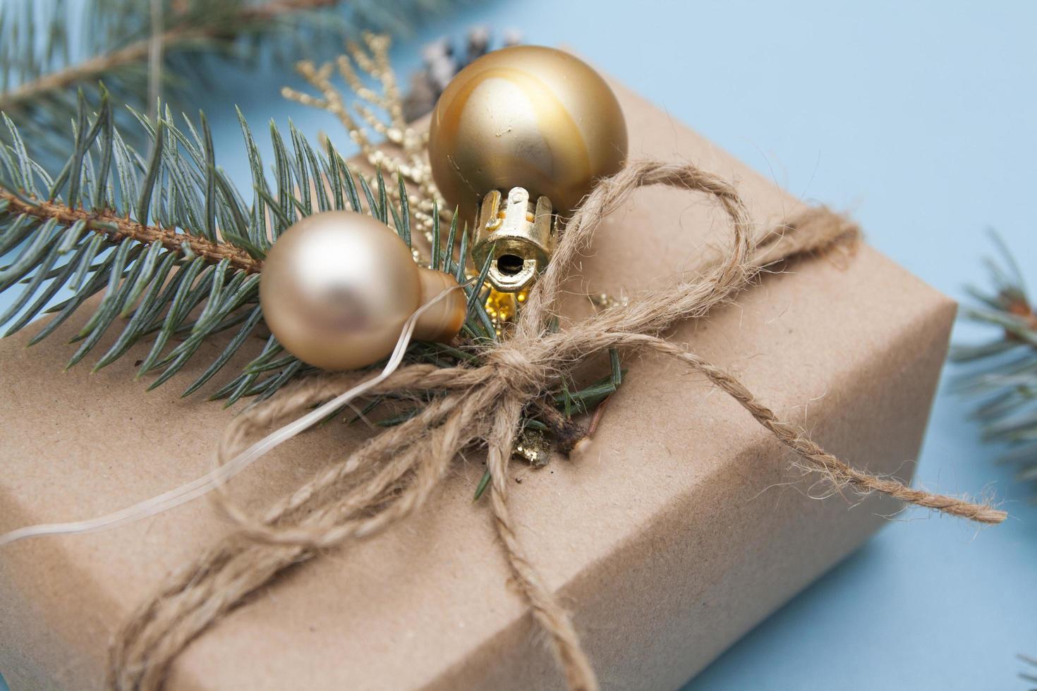 Christmas gift close up. Concept photo Christmas gift, New Year, winter holiday. Fir tree and golden twigs, decorations, garlands on a blue background. Copy space