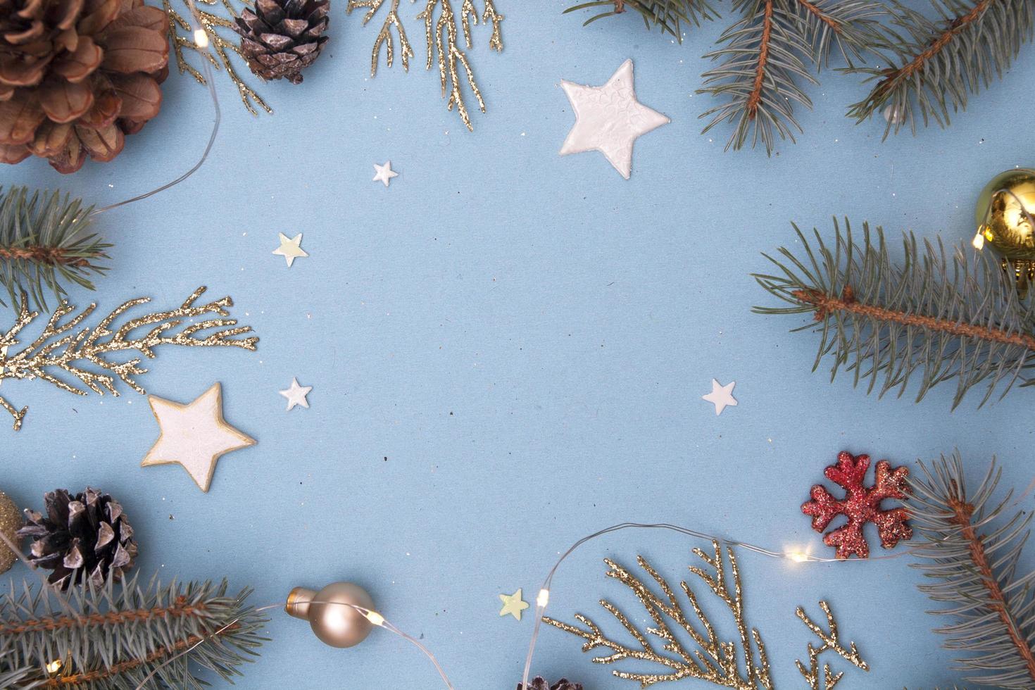 Christmas flat lay. Concept photo Christmas and New Year. Fir tree and golden twigs, decorations, garlands on a blue background. Copy space