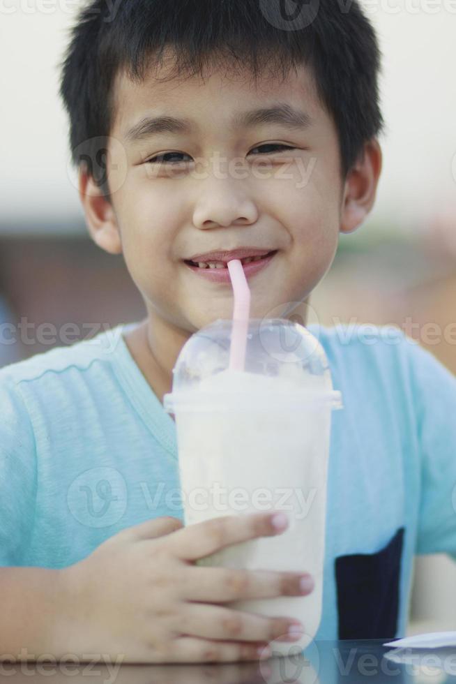 niños asiáticos bebiendo refrescos en cub de plástico foto