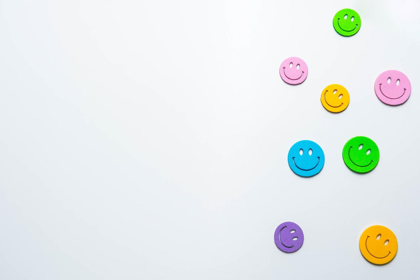 Multicolored emoticon icons on white paper photo