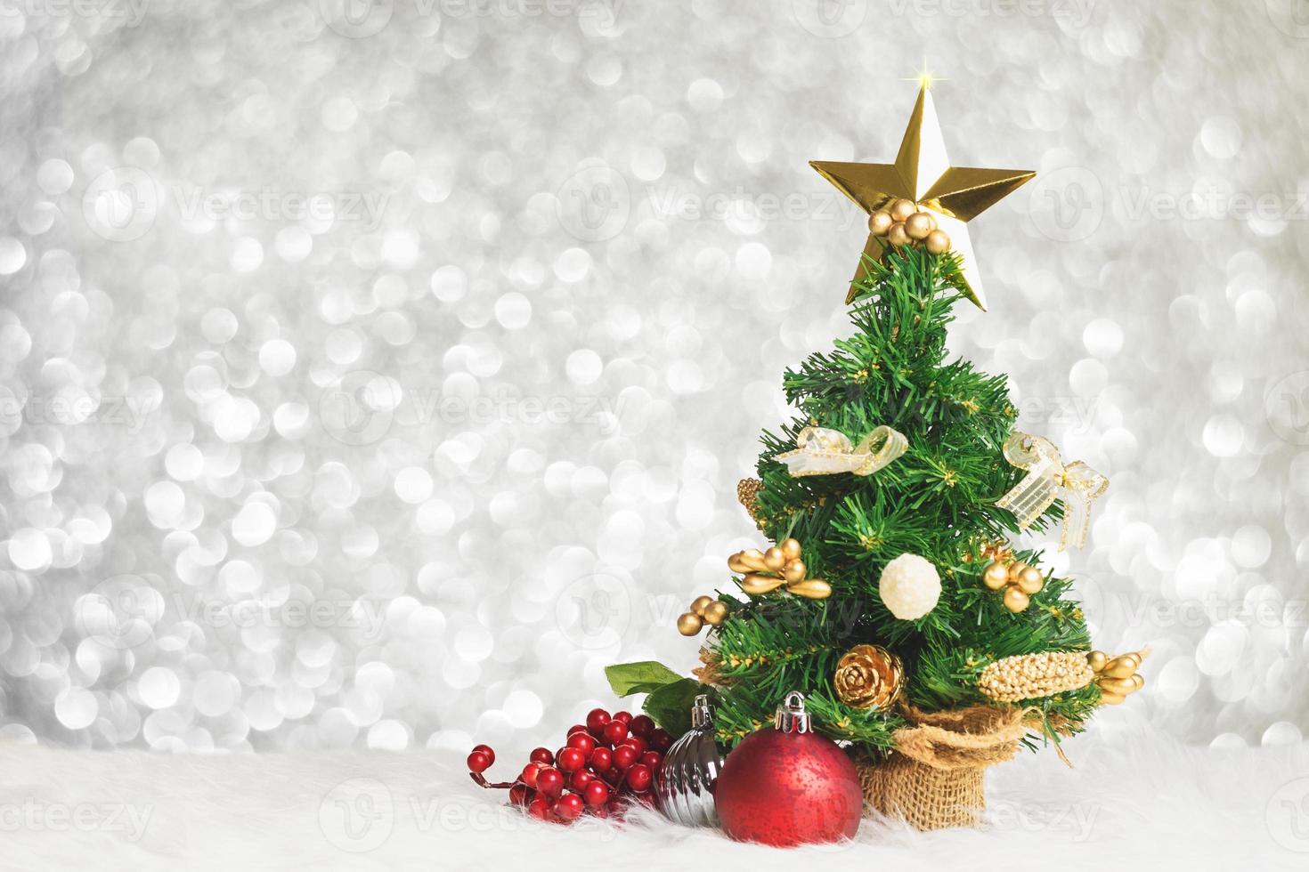 Christmas tree with cherry and ball decorate on white fur with blue silver bokeh photo