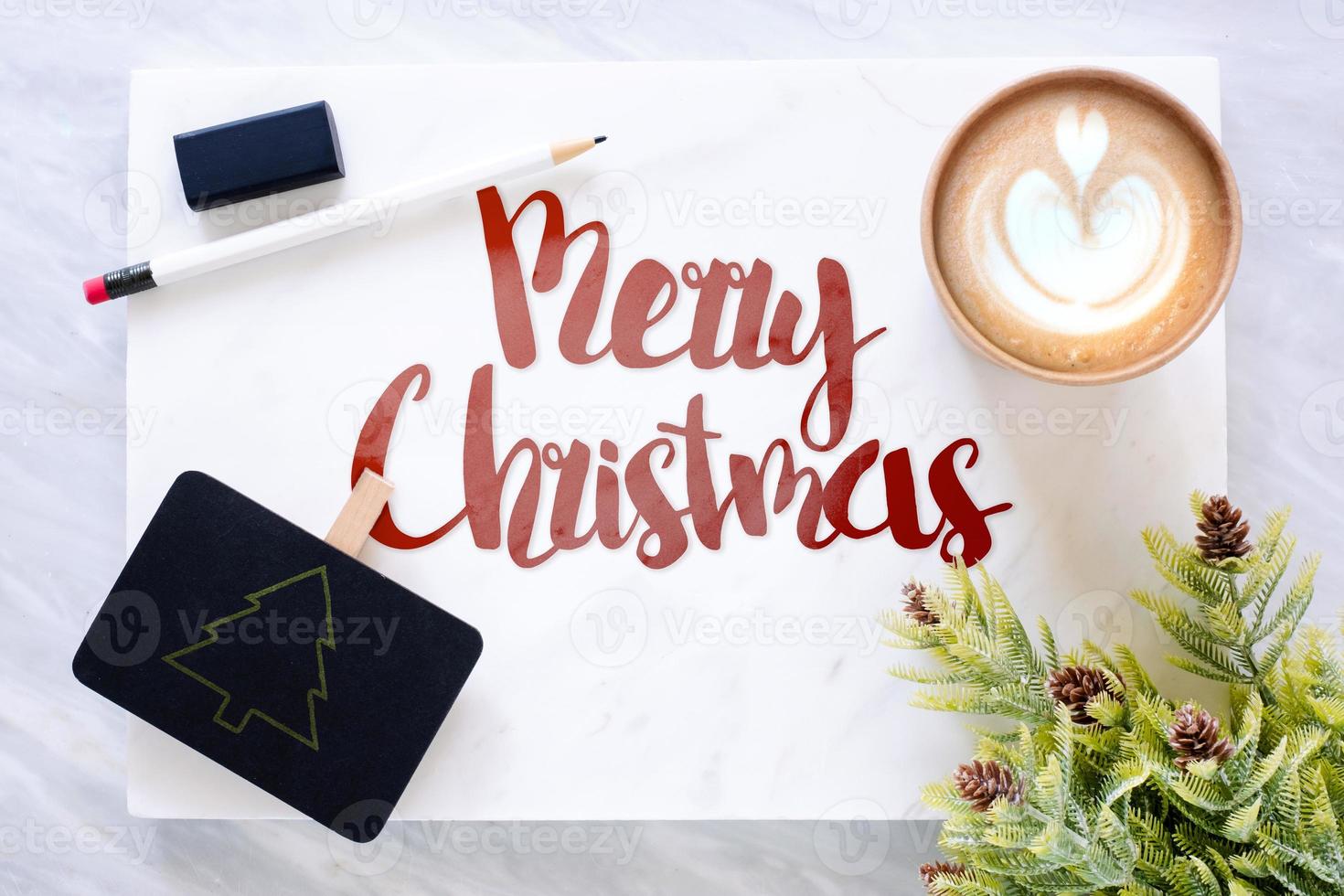 Top view of red merry christmas text on marble table with blackboard photo