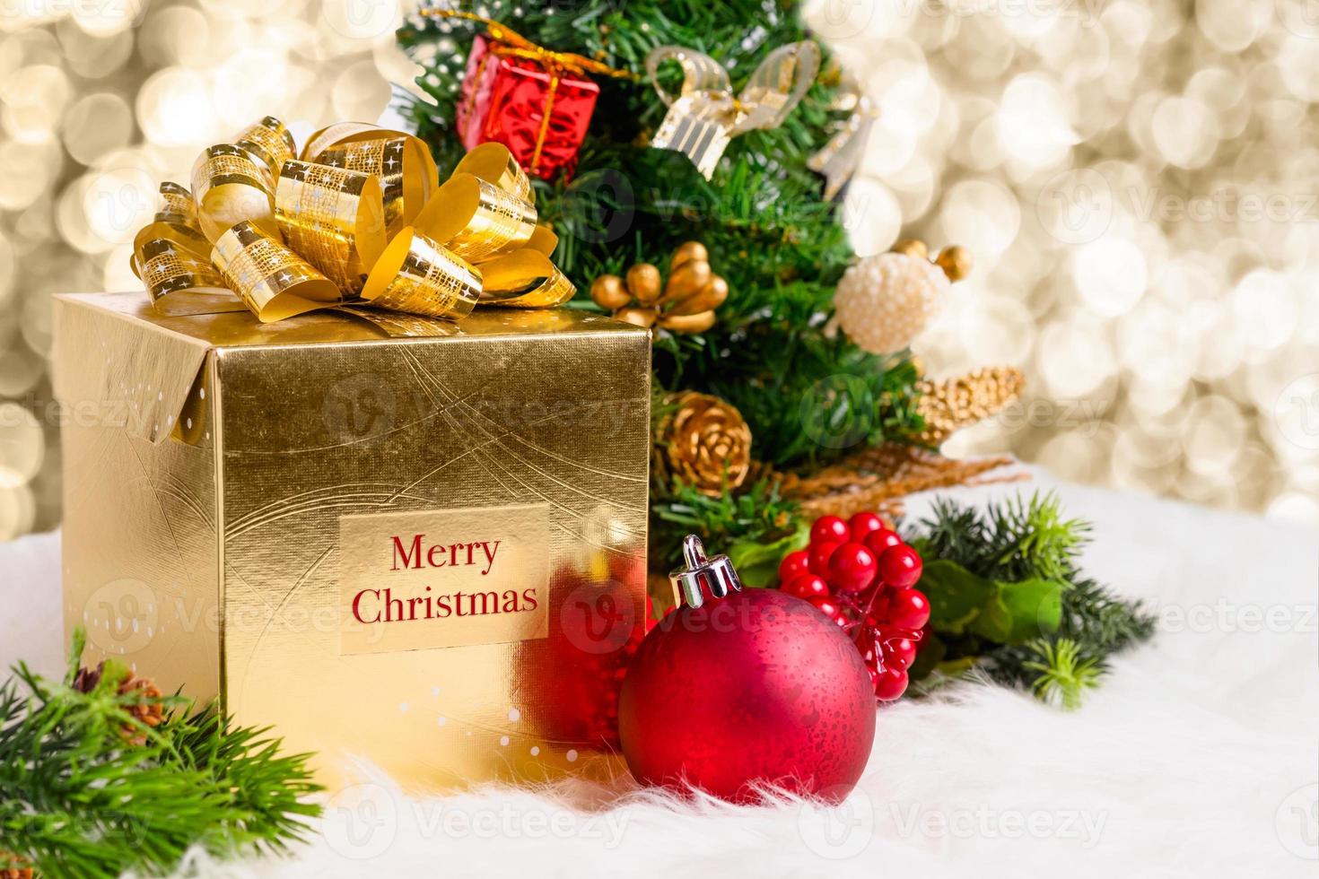 Shiny gold gift box with Merry Christmas word with red decoration photo