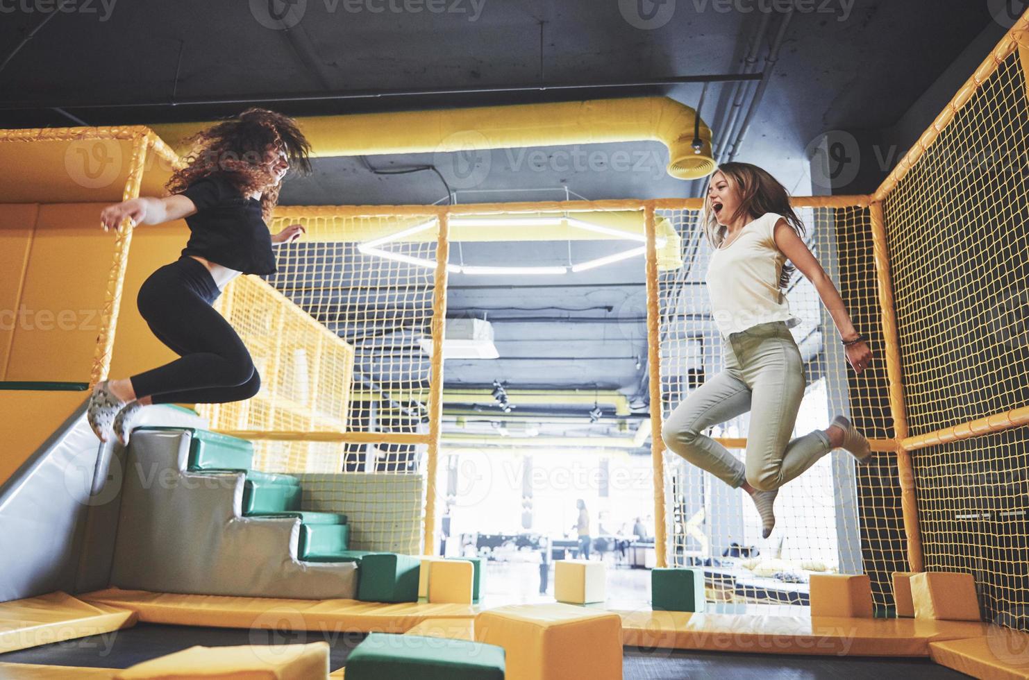 The company is a young woman who has fun with soft blocks on a children's playground in a trampoline center. photo