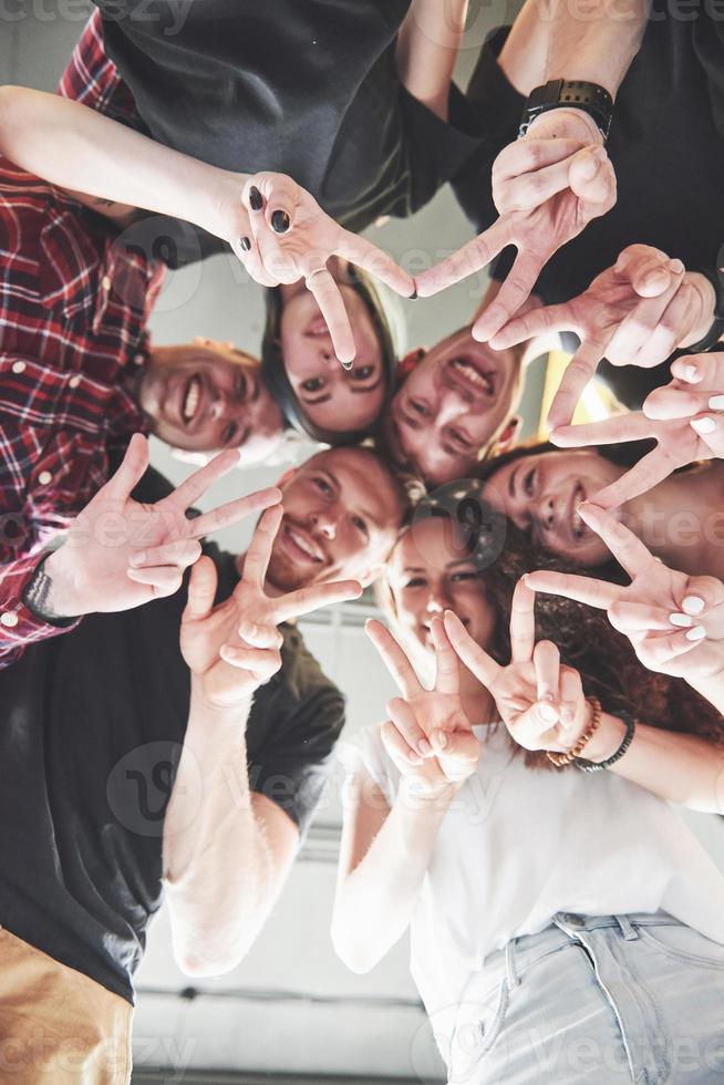 Happy group of friends with their hands together in the middle photo