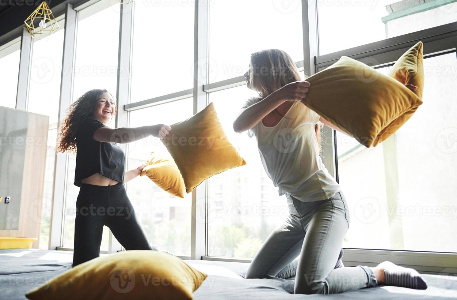 alegres novias felices están peleando con almohadas. foto