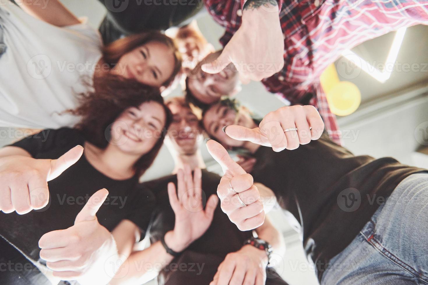 Happy group of friends with their hands together in the middle photo