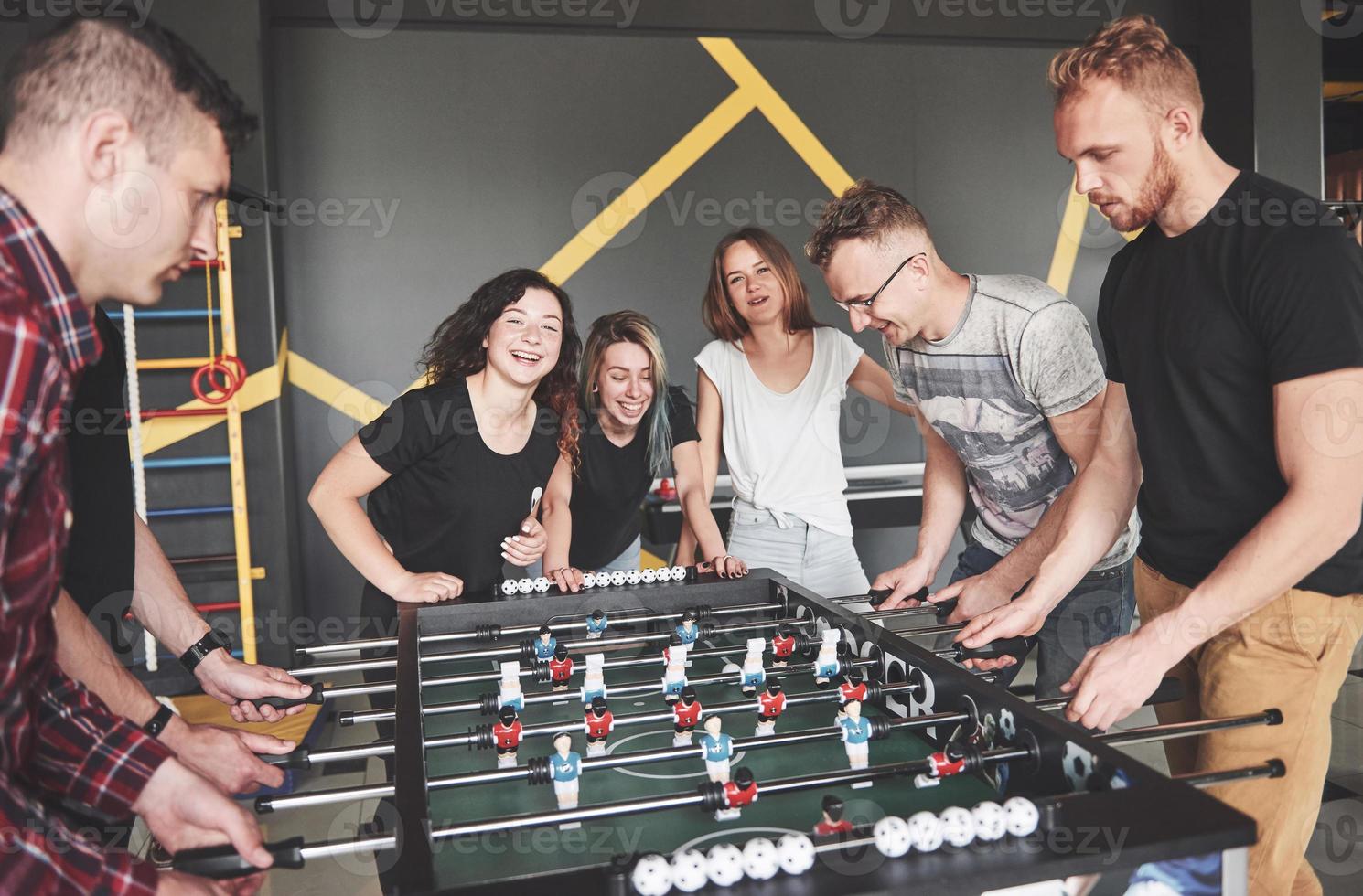 Friends together play board games, table football, have fun free time. photo