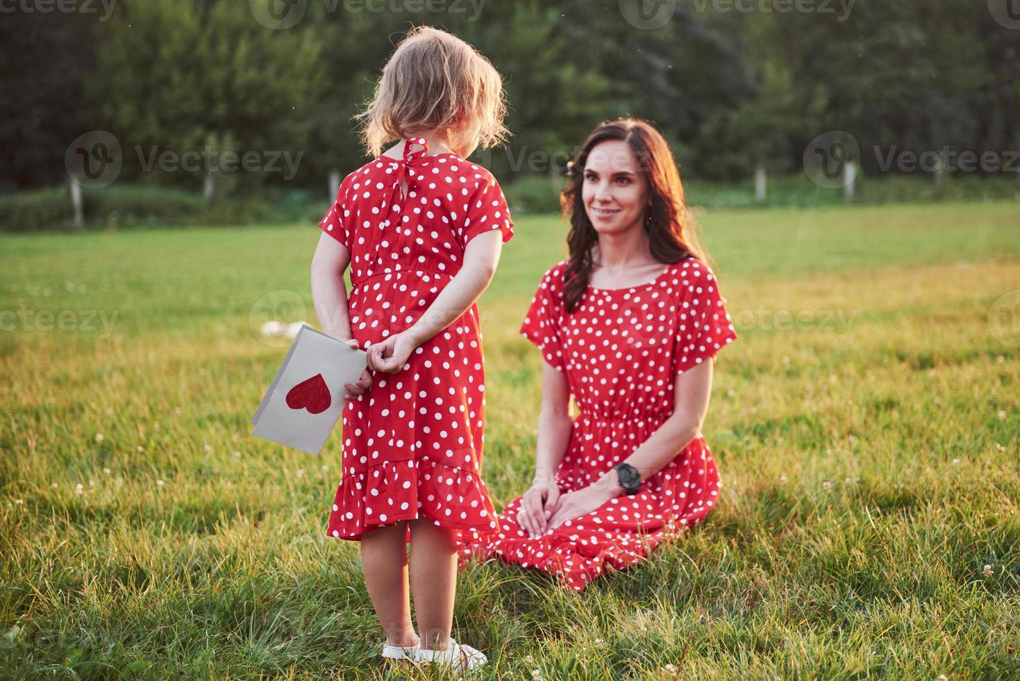 madre juega con su hija en la calle en el parque al atardecer foto