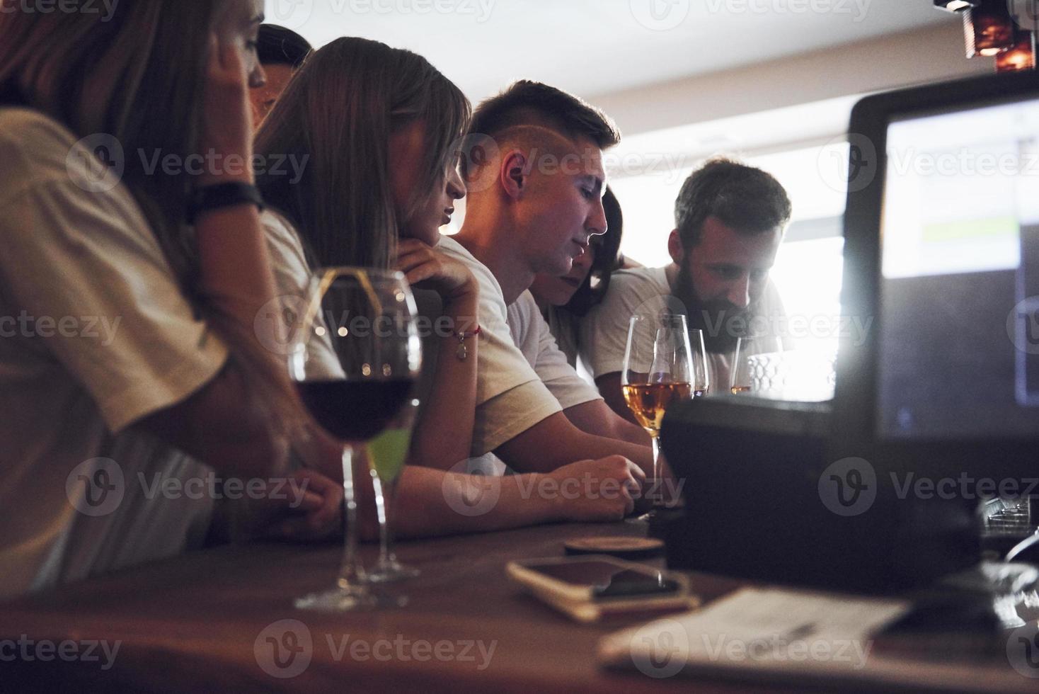 concepto de ocio y comunicación. Grupo de amigos sonrientes felices disfrutando de bebidas y hablando en el bar o pub foto