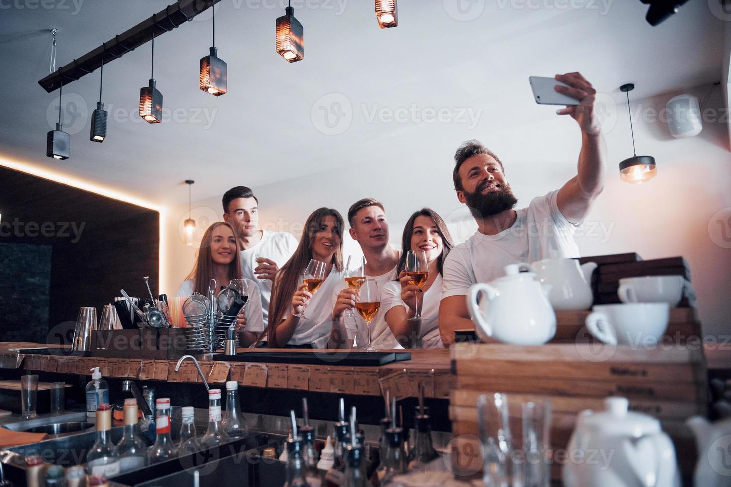 Leisure and communication concept. Group of happy smiling friends enjoying drinks and talking at bar or pub photo