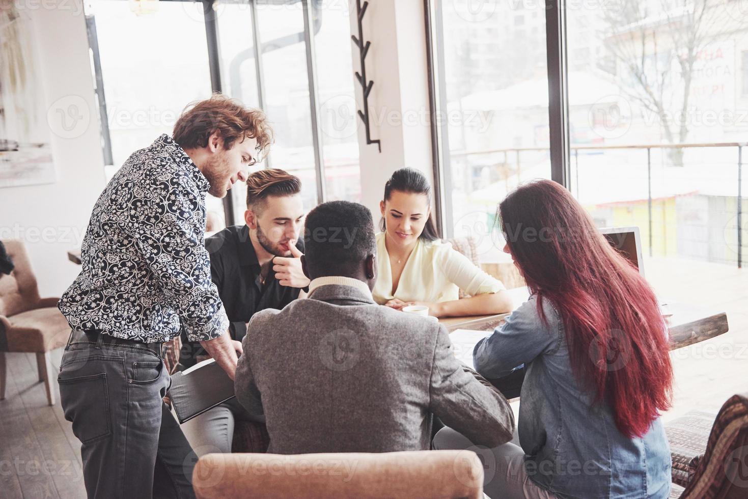 grupo de empresarios vestidos casualmente discutiendo ideas. profesionales creativos se reunieron para discutir los temas importantes del nuevo proyecto de inicio exitoso. concepto de lluvia de ideas de trabajo en equipo foto