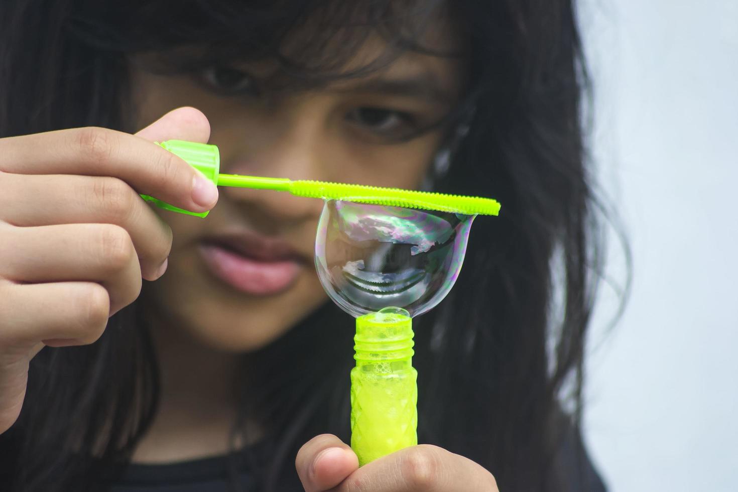 A girl holding a bubble maker and blowing them out. photo