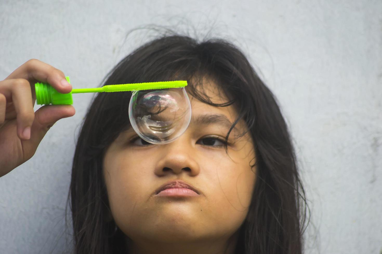 A girl holding a bubble maker and blowing them out. photo