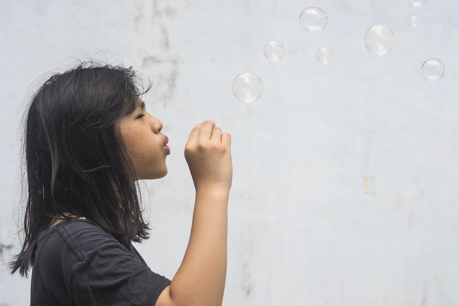 A girl holding a bubble maker and blowing them out. photo