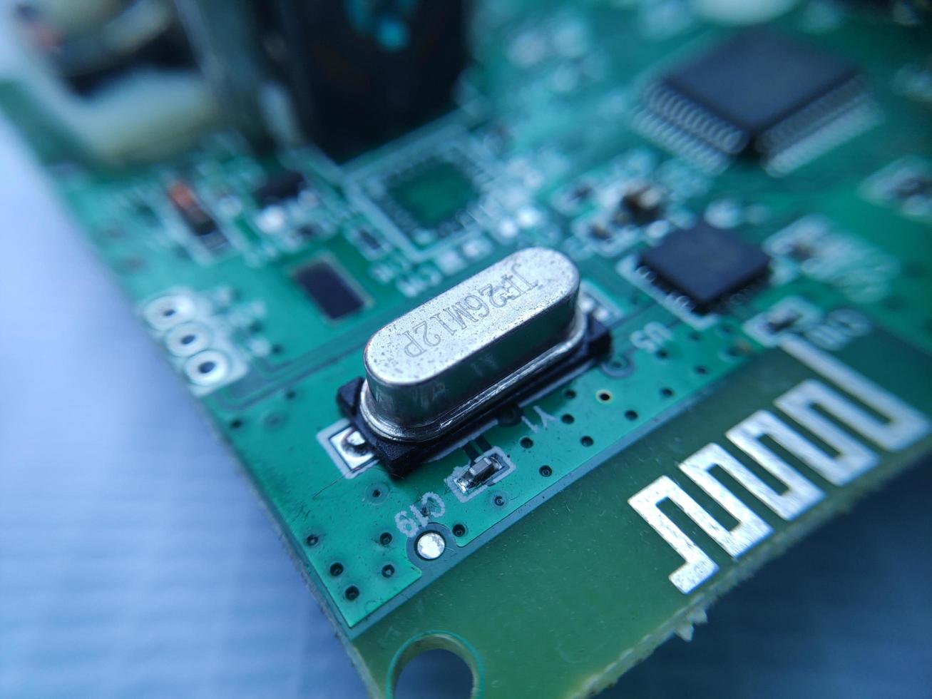 Close up image of crystal oscillator or electronic oscillator circuit. Electronic component. photo