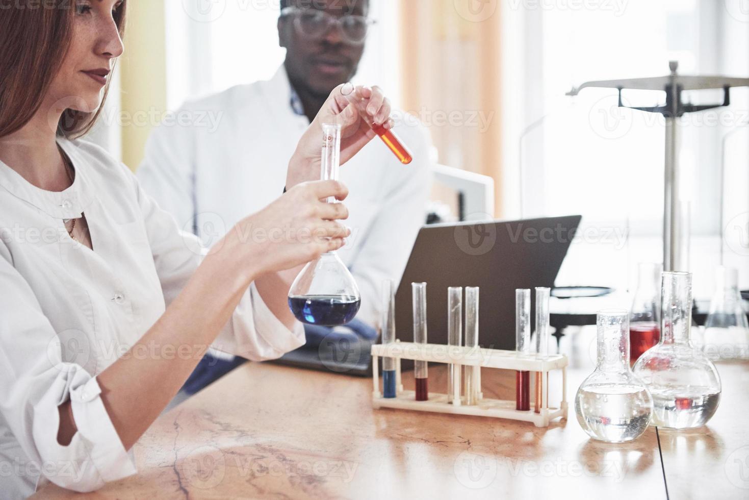 Laboratory laboratories conduct experiments in a chemical laboratory in transparent flasks. Output formulas photo